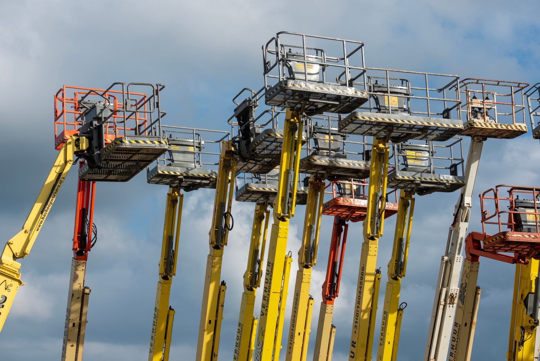 Skylift i arbete på byggarbetsplats med säkerhetsavspärrning.
